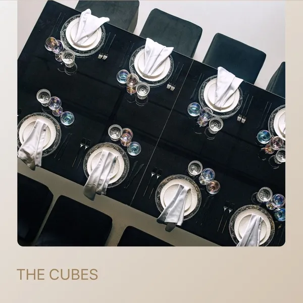 Minimalist black tablescape with square cube poufs — perfect for meetings or workshops.