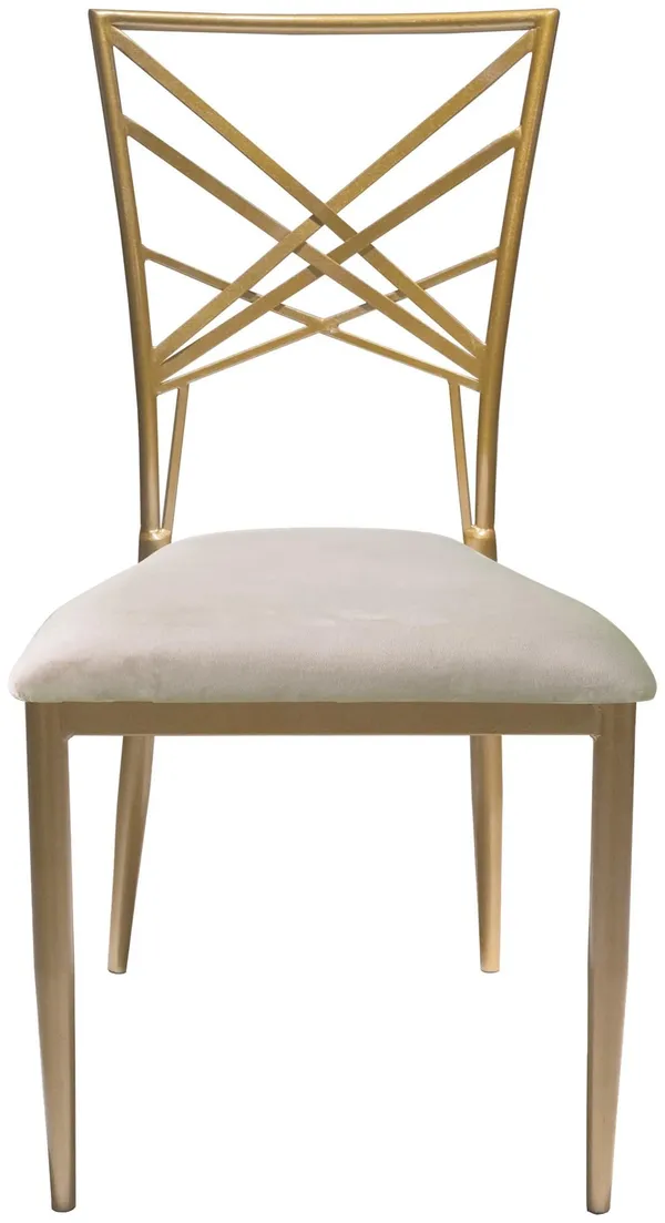 Gold lattice-back chair with a beige velvet seat styled in a warm-toned dining setup with elegant tableware and soft lighting.